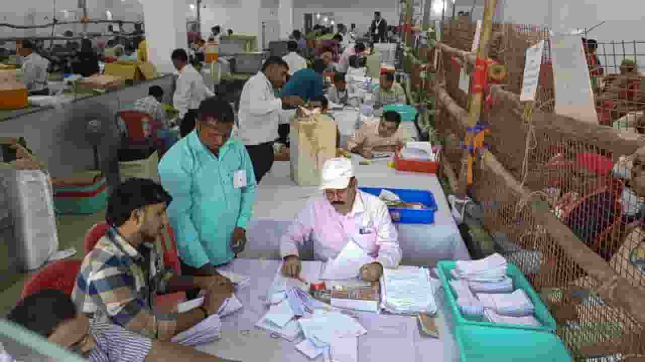 मतगणना केंद्र पर वोटों की गिनती करते कर्मचारी