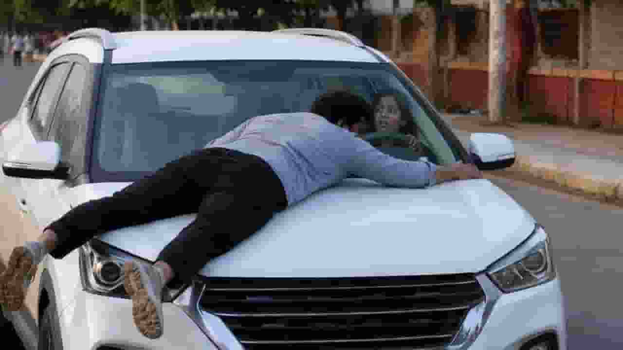 Man climbs onto car